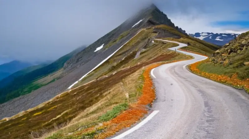 La carretera serpentea montaña arriba por un estrecho asfalto sobre una pendiente escarpada hasta la cima de una montaña nevada