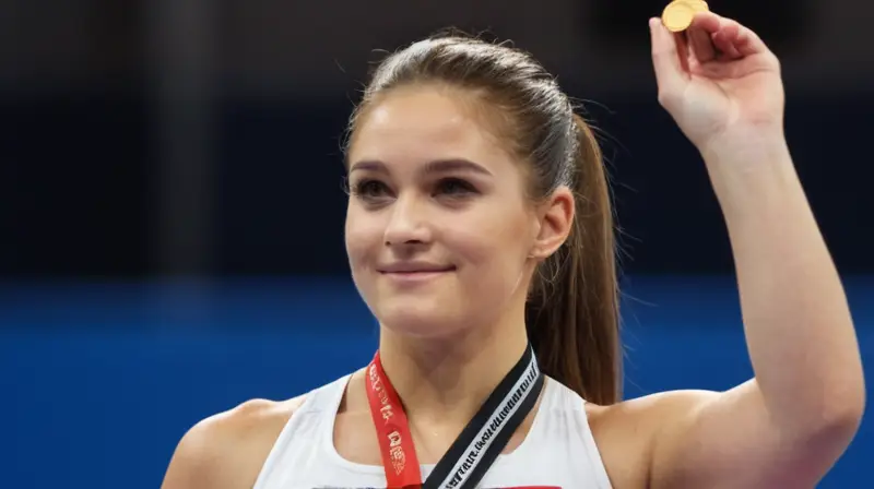 Una atleta femenina victoriosa lucía un medallón dorado mientras recibía los aplausos de la multitud en una arena deportiva iluminada por una gran ventana solar