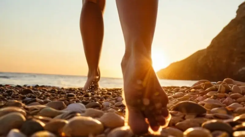 Una joven corriendo descalza por una playa rocosa al atardecer