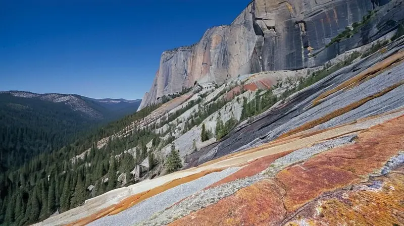 El Capitán es un impresionante acantilado vertical de 2.900 pies de altura con una superficie rocosa rugosa mostrando capas de cuarzo rojo