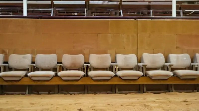 El escenario retrata un viejo estadio con una pista de atletismo detrás de un pared de piedra desgastada