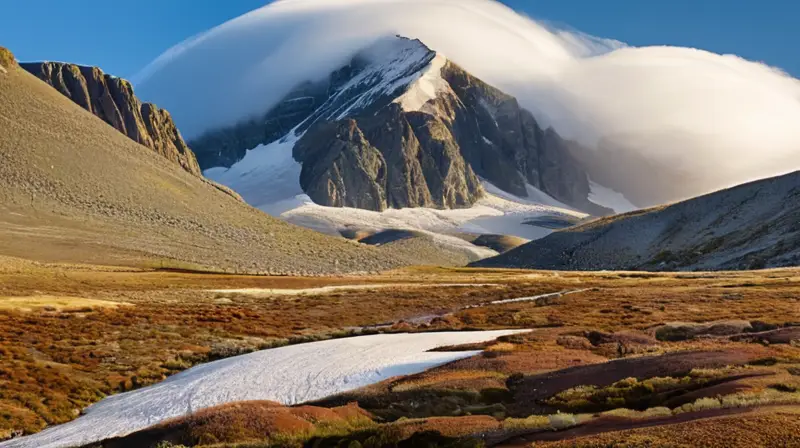 La cumbre nevada emergía lentamente de las nubes densas rodeada de rocas graníticas y flora estropajosa