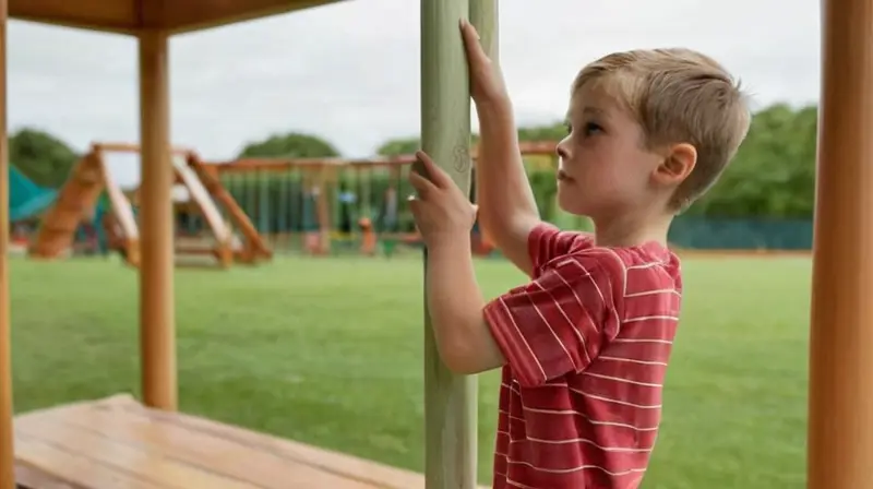 Un niño de 7-8 años se entrena con una serie de estiramientos en un campo verde bajo luz natural difusa