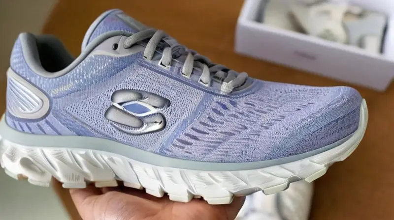 Una persona sostiene una zapatilla con reflejos brillantes en un entorno diáfano